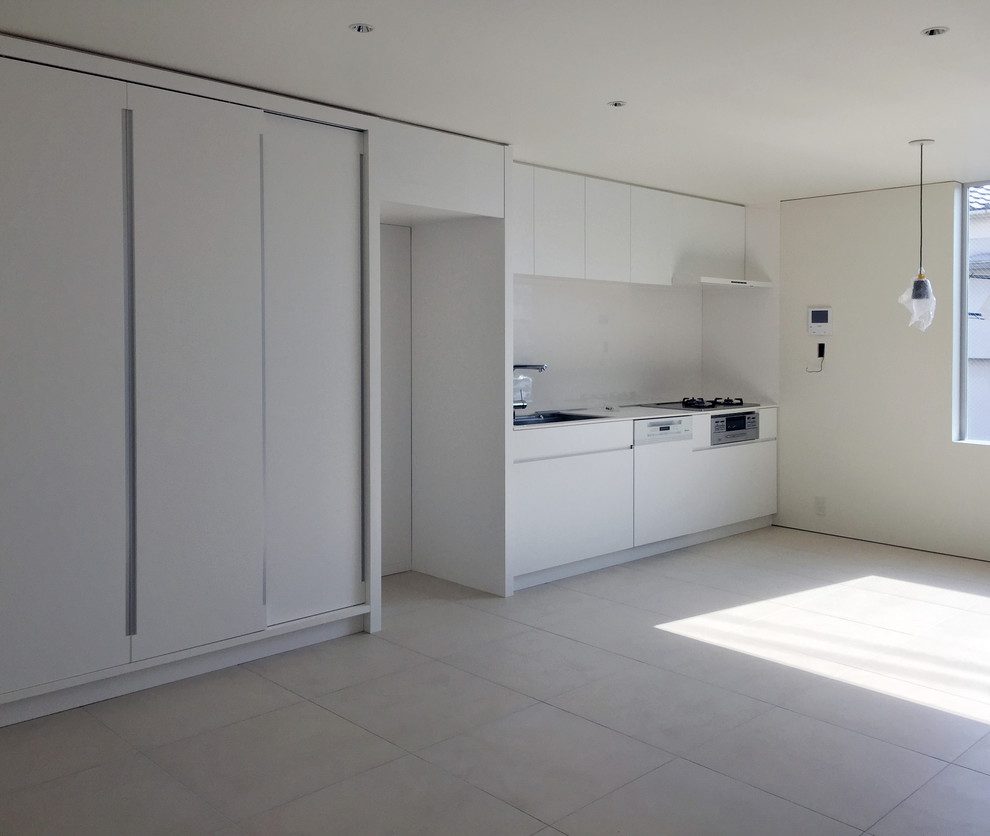 This is an example of a small modern single-wall kitchen in Osaka with an undermount sink, beaded inset cabinets, white cabinets, solid surface benchtops, white splashback and ceramic floors.