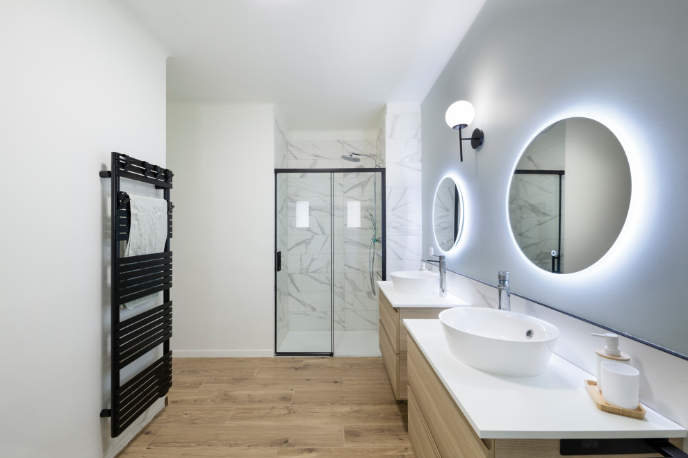 This is an example of a bathroom in Marseille with a freestanding bath, an alcove shower, wood-effect flooring, a vessel sink and double sinks.