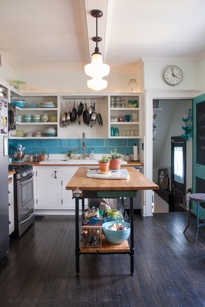 Inspiration for a mid-sized eclectic l-shaped eat-in kitchen in Columbus with open cabinets, white cabinets, wood benchtops, blue splashback, ceramic splashback, stainless steel appliances, dark hardwood floors, with island and a drop-in sink.