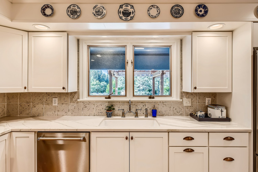 Photo of an u-shaped kitchen in Denver with shaker cabinets, white cabinets, quartzite benchtops, white splashback, stainless steel appliances, medium hardwood floors and white benchtop.