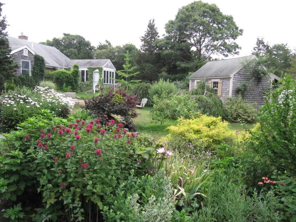 This is an example of a mid-sized country backyard full sun formal garden for spring in Boston with a garden path.
