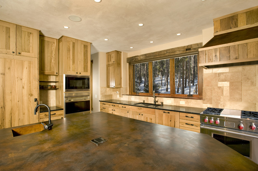 This is an example of a large country l-shaped eat-in kitchen in Denver with light wood cabinets, stainless steel appliances, medium hardwood floors, with island, a drop-in sink, flat-panel cabinets, wood benchtops, beige splashback and ceramic splashback.