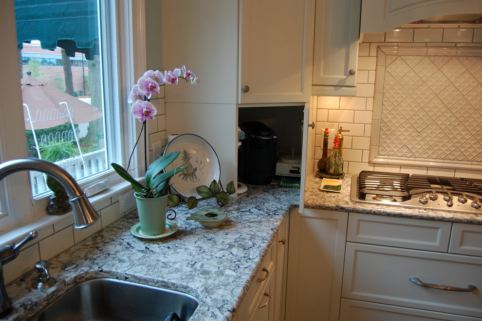 Inspiration for a transitional u-shaped eat-in kitchen remodel in Raleigh with an undermount sink, recessed-panel cabinets, white cabinets, quartzite countertops, white backsplash, subway tile backsplash and stainless steel appliances