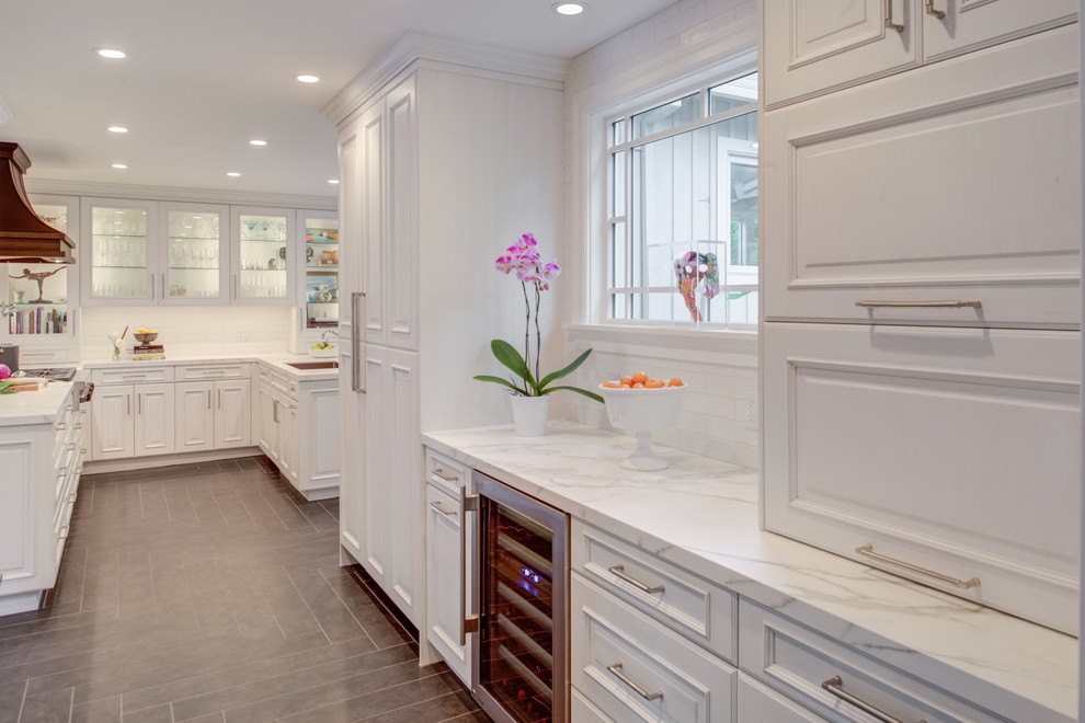 Inspiration for a traditional u-shaped kitchen in San Francisco with an undermount sink, raised-panel cabinets, white cabinets, quartz benchtops, white splashback, subway tile splashback, panelled appliances, grey floor, white benchtop and ceramic floors.