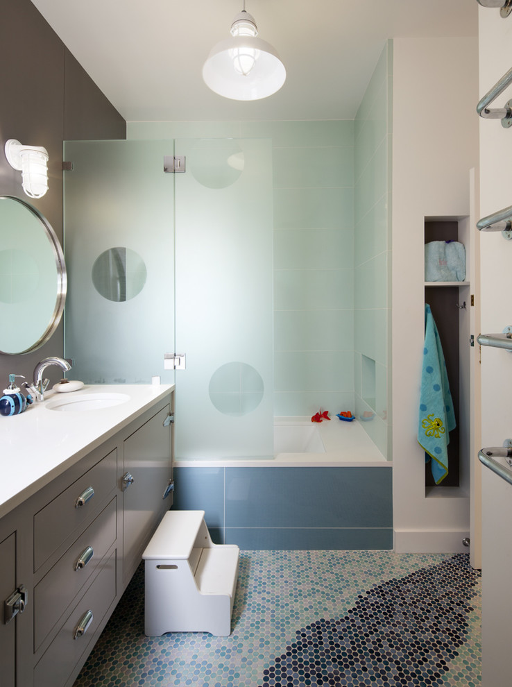 This is an example of a mid-sized contemporary kids bathroom in San Francisco with mosaic tile floors, an undermount tub, a shower/bathtub combo, a wall-mount sink, a hinged shower door and a floating vanity.