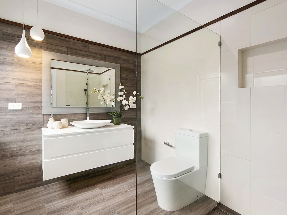 Photo of a contemporary 3/4 bathroom in Melbourne with flat-panel cabinets, white cabinets, an open shower, brown tile, white tile, white walls, a vessel sink, brown floor and an open shower.