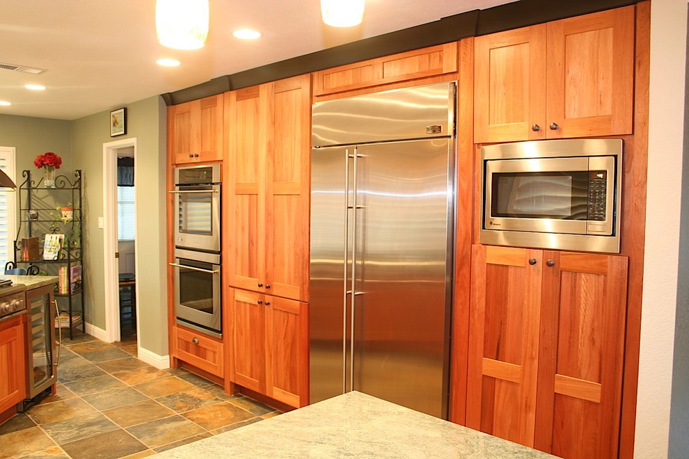 Kitchen - mid-sized transitional u-shaped slate floor kitchen idea with an undermount sink, recessed-panel cabinets, medium tone wood cabinets, granite countertops, green backsplash, stone tile backsplash, stainless steel appliances and no island