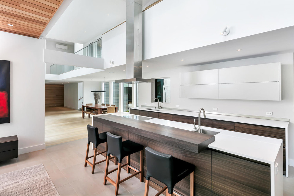 Inspiration for a mid-sized contemporary galley open plan kitchen in New York with an undermount sink, flat-panel cabinets, quartz benchtops, stainless steel appliances, ceramic floors, with island, beige floor, white benchtop and dark wood cabinets.