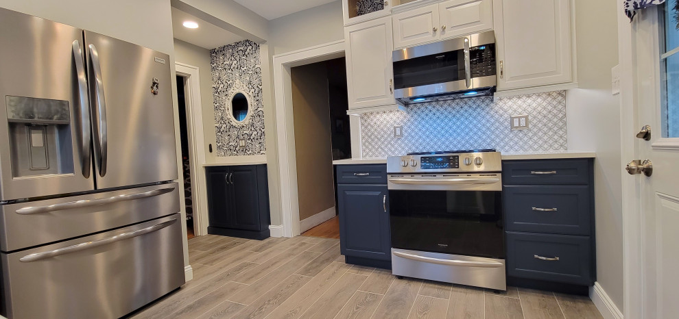 Inspiration for a porcelain tile enclosed kitchen remodel with quartz countertops, mosaic tile backsplash, stainless steel appliances and no island