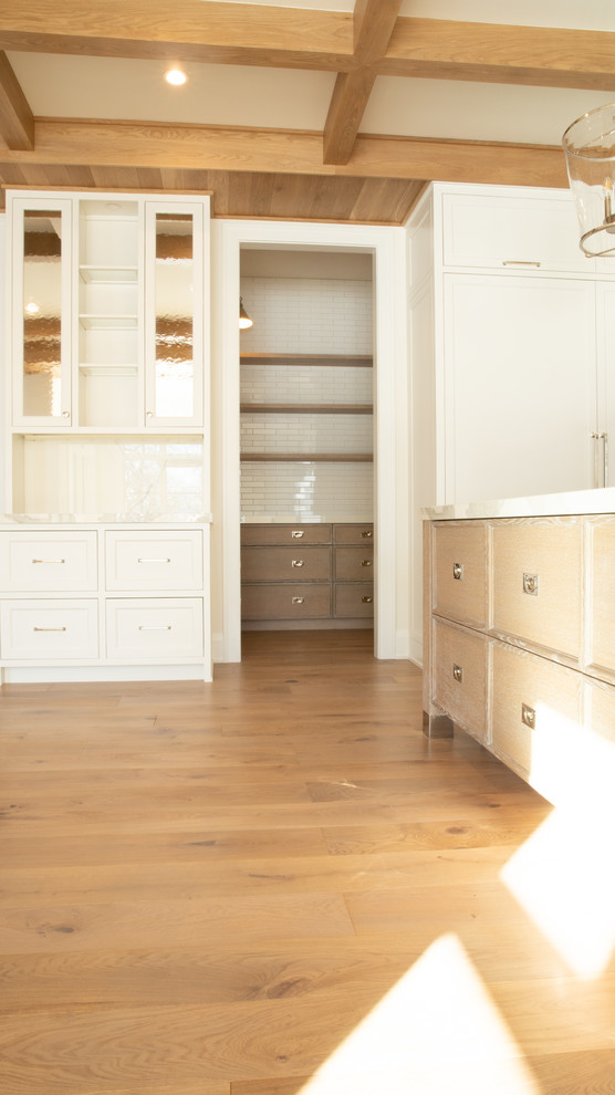 Bild på ett mellanstort funkis vit vitt kök, med luckor med profilerade fronter, vita skåp, marmorbänkskiva, vitt stänkskydd, stänkskydd i marmor, ljust trägolv, en köksö och brunt golv