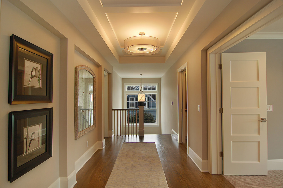 This is an example of a transitional hallway in Minneapolis with beige walls and brown floor.