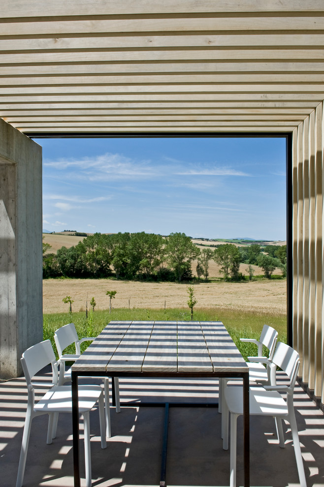Inspiration for a mid-sized modern patio in Other with concrete slab and a pergola.