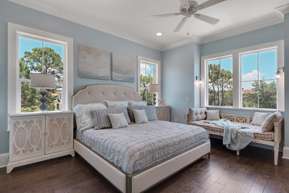 This is an example of a large beach style guest bedroom in Miami with blue walls, medium hardwood floors and no fireplace.