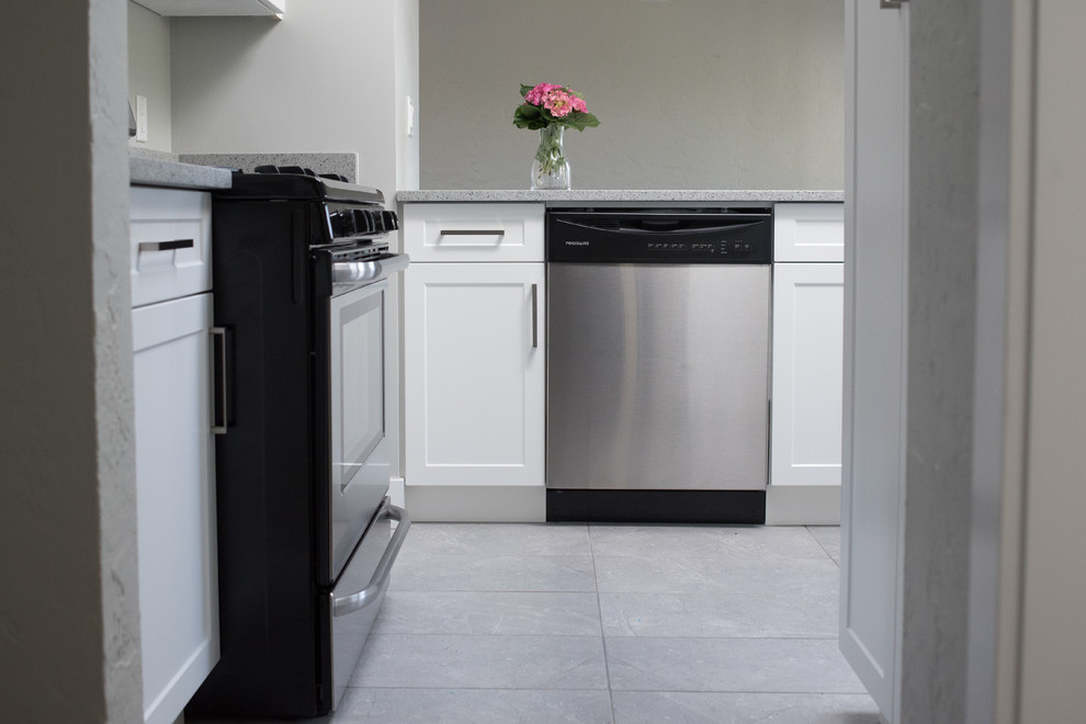 Eat-in kitchen - transitional l-shaped ceramic tile eat-in kitchen idea in Vancouver with a double-bowl sink, shaker cabinets, white cabinets, granite countertops, stainless steel appliances and an island