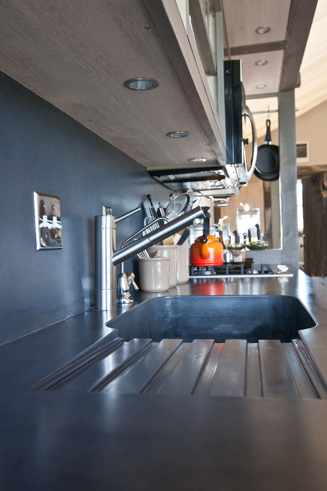 Example of a mountain style home design design with an integrated sink, concrete countertops, gray backsplash and cement tile backsplash