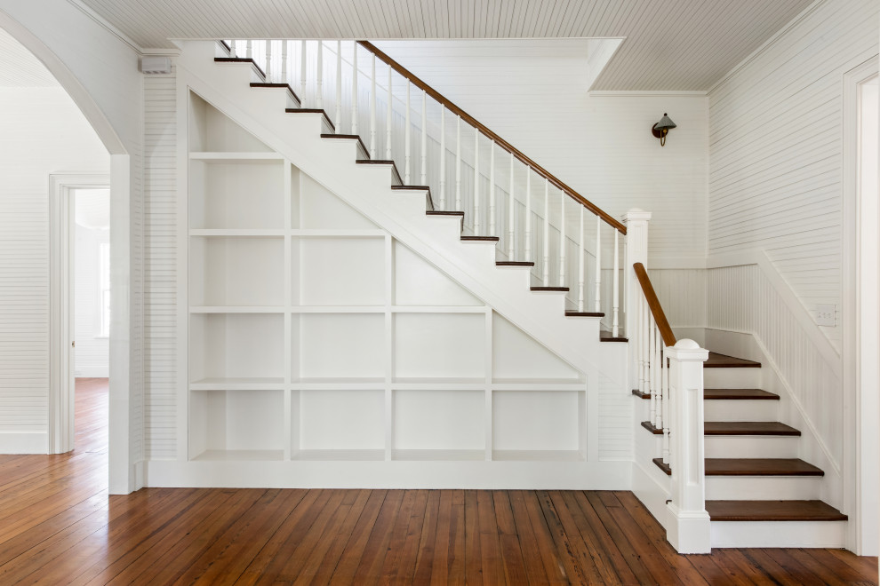 Staircase - traditional wooden l-shaped wood railing and wall paneling staircase idea in Charleston with painted risers