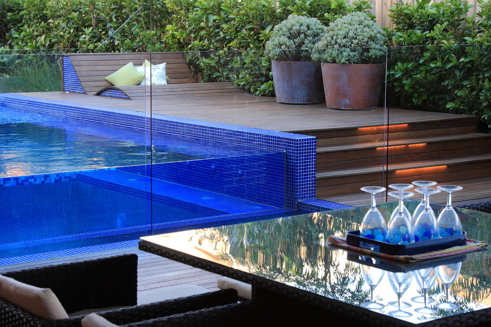 This is an example of a mid-sized contemporary backyard full sun garden in Sydney with a water feature and decking.