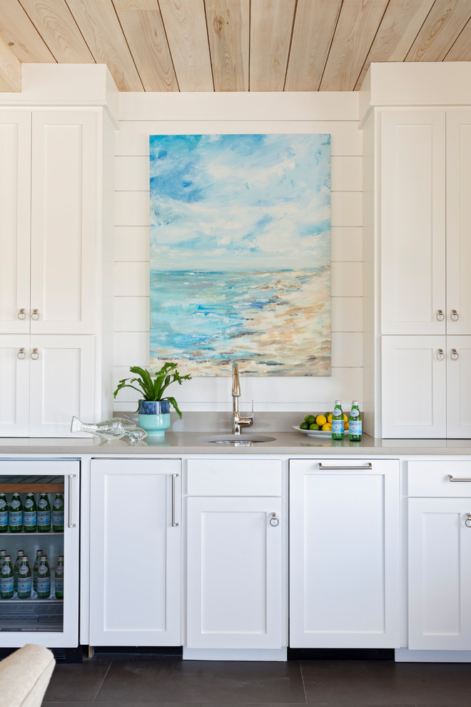 Inspiration for a beach style single-wall wet bar in Charleston with an undermount sink, shaker cabinets, white cabinets, white splashback, timber splashback and grey benchtop.