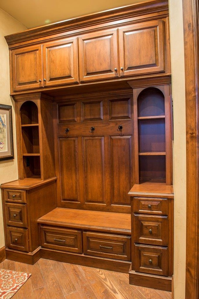This is an example of a large traditional mudroom in Other with beige walls and vinyl floors.