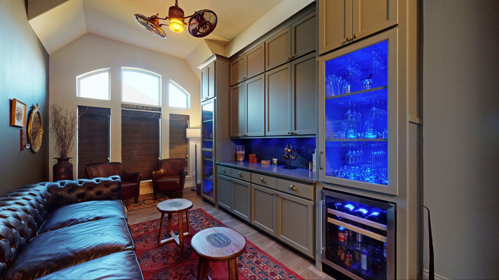 Photo of a large traditional single-wall home bar in Dallas with no sink, shaker cabinets, grey cabinets, granite benchtops, brown splashback, ceramic splashback, ceramic floors, grey floor and grey benchtop.