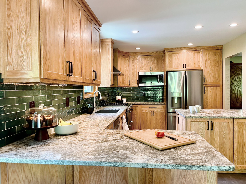 Mid-sized transitional u-shaped vinyl floor and gray floor kitchen pantry photo with an undermount sink, shaker cabinets, light wood cabinets, granite countertops, green backsplash, porcelain backsplash, stainless steel appliances, a peninsula and gray countertops