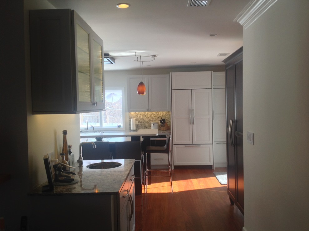 Example of a large transitional galley medium tone wood floor open concept kitchen design in Chicago with an undermount sink, recessed-panel cabinets, white cabinets, quartz countertops and paneled appliances