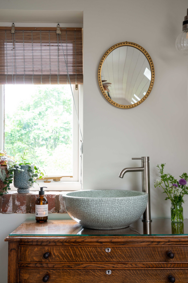 Bild på ett mellanstort minimalistiskt en-suite badrum, med luckor med profilerade fronter, skåp i mellenmörkt trä, ett fristående badkar, en kantlös dusch, kakel i småsten, ljust trägolv, träbänkskiva och dusch med skjutdörr