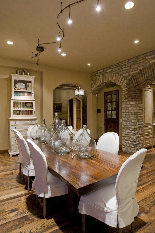 This is an example of a mediterranean dining room in Phoenix with beige walls and dark hardwood floors.