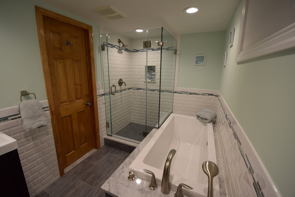 Design ideas for a mid-sized transitional bathroom in New York with a trough sink, recessed-panel cabinets, dark wood cabinets, a drop-in tub, a corner shower, a two-piece toilet, white tile, ceramic tile, green walls, ceramic floors and grey floor.