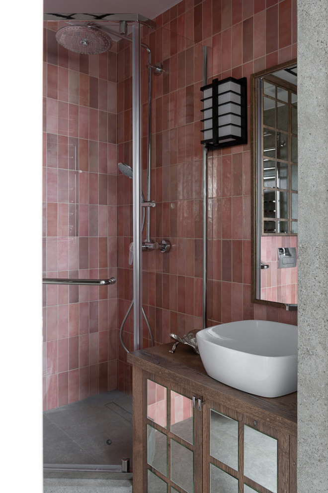 Photo of a medium sized world-inspired ensuite bathroom in Other with glass-front cabinets, dark wood cabinets, a corner shower, a wall mounted toilet, pink tiles, ceramic tiles, pink walls, porcelain flooring, a built-in sink, laminate worktops, grey floors, a hinged door, brown worktops, a single sink, a freestanding vanity unit, exposed beams and panelled walls.