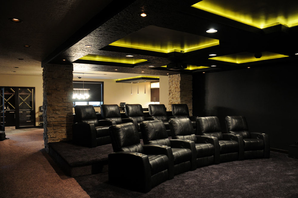 Photo of a large contemporary enclosed home theatre in Other with black walls, carpet and a projector screen.