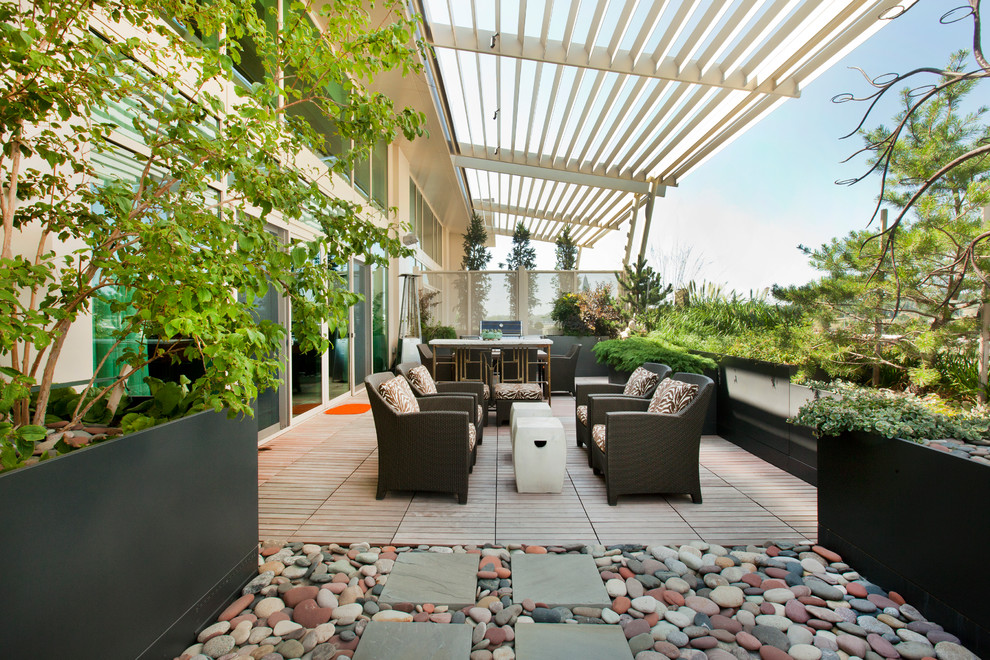 Design ideas for an expansive contemporary courtyard patio in Omaha with an outdoor kitchen, decking and an awning.