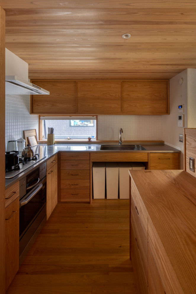 Medium sized l-shaped open plan kitchen in Other with an integrated sink, stainless steel worktops, wood splashback, stainless steel appliances, painted wood flooring, an island and a wood ceiling.