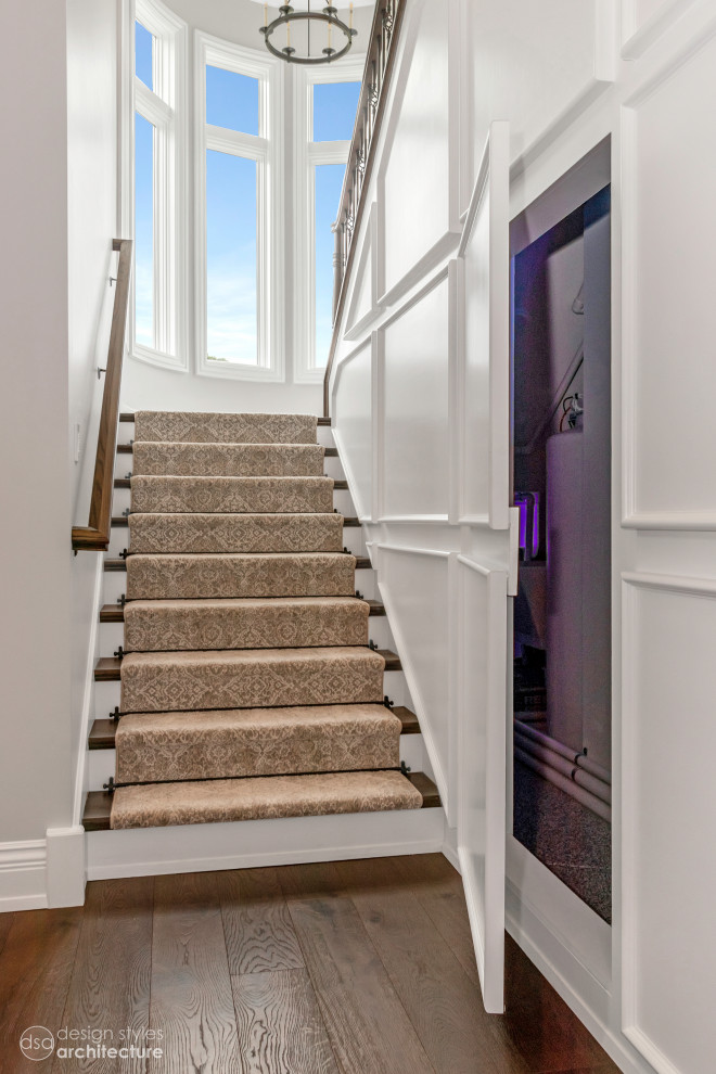 Стильный дизайн: большая п-образная лестница в классическом стиле с деревянными ступенями, крашенными деревянными подступенками, деревянными перилами и панелями на стенах - последний тренд