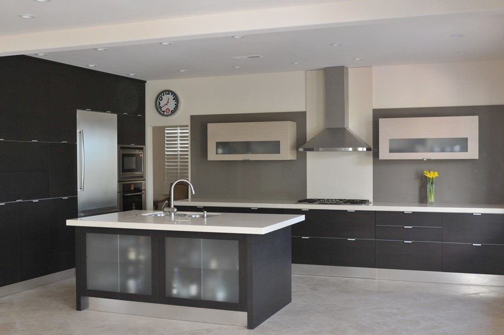 Inspiration for a large modern l-shaped eat-in kitchen in Orange County with a double-bowl sink, flat-panel cabinets, black cabinets, quartz benchtops, grey splashback, stainless steel appliances, limestone floors and with island.