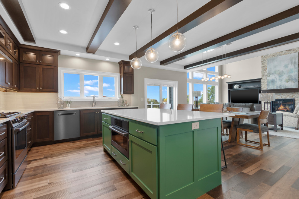 Example of a mid-sized transitional l-shaped medium tone wood floor, brown floor and tray ceiling eat-in kitchen design with an undermount sink, shaker cabinets, medium tone wood cabinets, quartz countertops, gray backsplash, glass tile backsplash, black appliances, an island and white countertops
