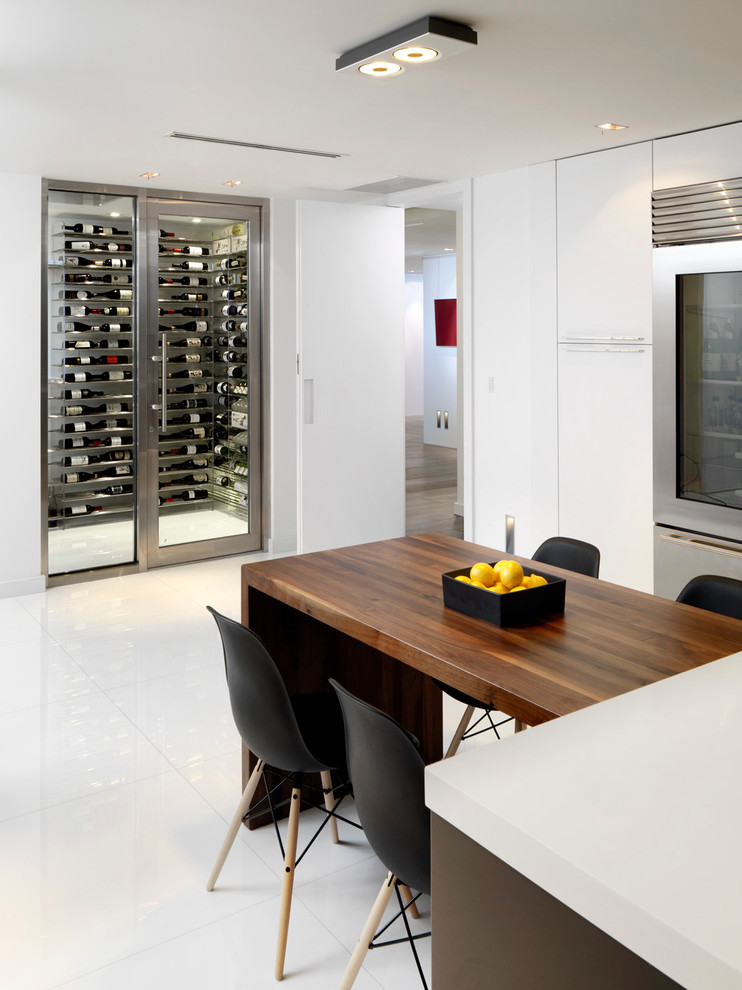 Photo of a contemporary l-shaped eat-in kitchen in Miami with flat-panel cabinets, white cabinets, stainless steel appliances and with island.
