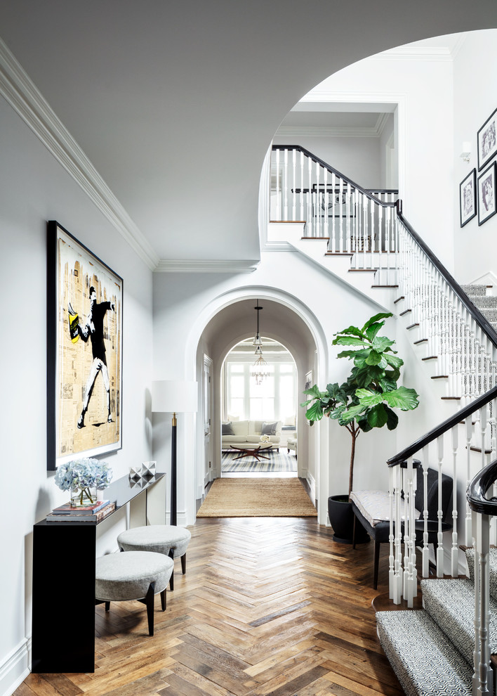 Traditional hallway in New York with white walls, medium hardwood floors and brown floor.