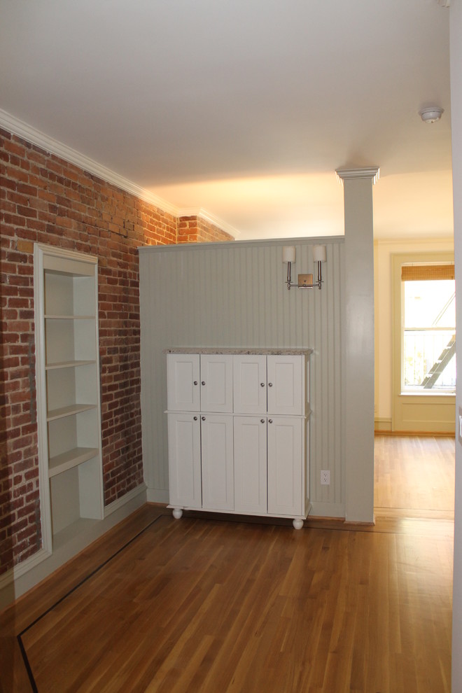 Photo of a small traditional loft-style bedroom in New York with white walls, light hardwood floors and no fireplace.