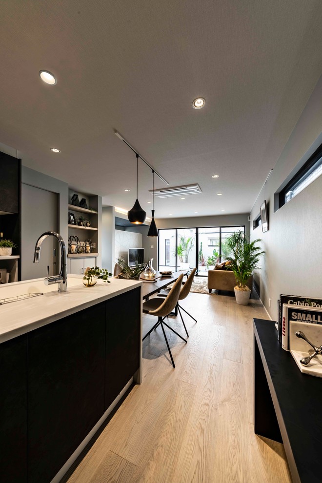 Mid-sized modern single-wall separate kitchen in Other with an integrated sink, glass-front cabinets, black cabinets, solid surface benchtops, brown splashback, panelled appliances, plywood floors, with island, grey floor and white benchtop.