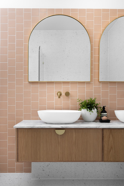 Pink Vertical Subway Tiles with Arched Mirrors and Wood Vanity