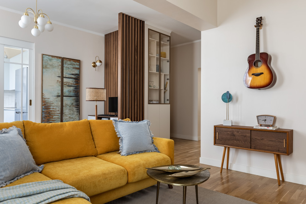 Стильный дизайн: гостиная комната среднего размера в современном стиле с паркетным полом среднего тона, коричневым полом и горчичным диваном без телевизора - последний тренд