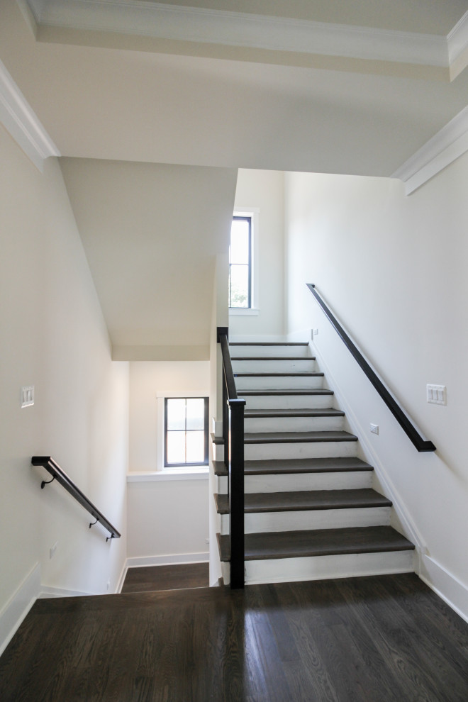 This is an example of a mid-sized contemporary wood u-shaped staircase in DC Metro with wood risers and metal railing.