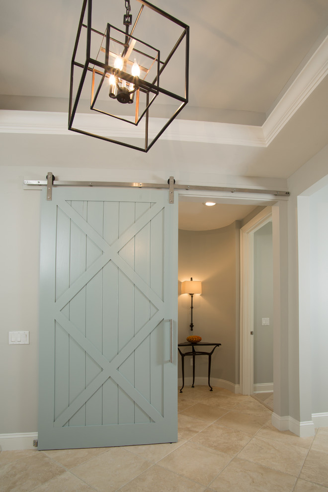 This is an example of a mid-sized beach style hallway in Jacksonville with beige walls, travertine floors and beige floor.