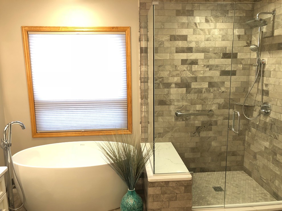 Photo of a transitional master bathroom in Minneapolis with beaded inset cabinets, white cabinets, a freestanding tub, a corner shower, gray tile, stone tile, grey walls, slate floors, engineered quartz benchtops, grey floor and a hinged shower door.