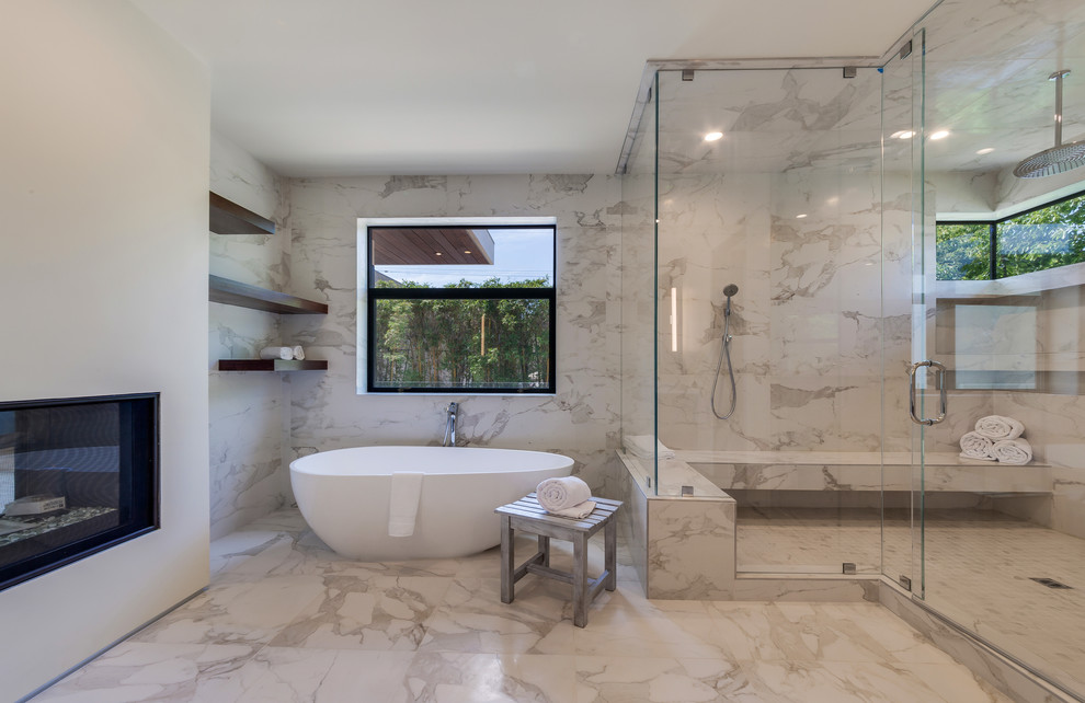 Photo of a contemporary bathroom in Los Angeles with a freestanding tub, white walls and white floor.