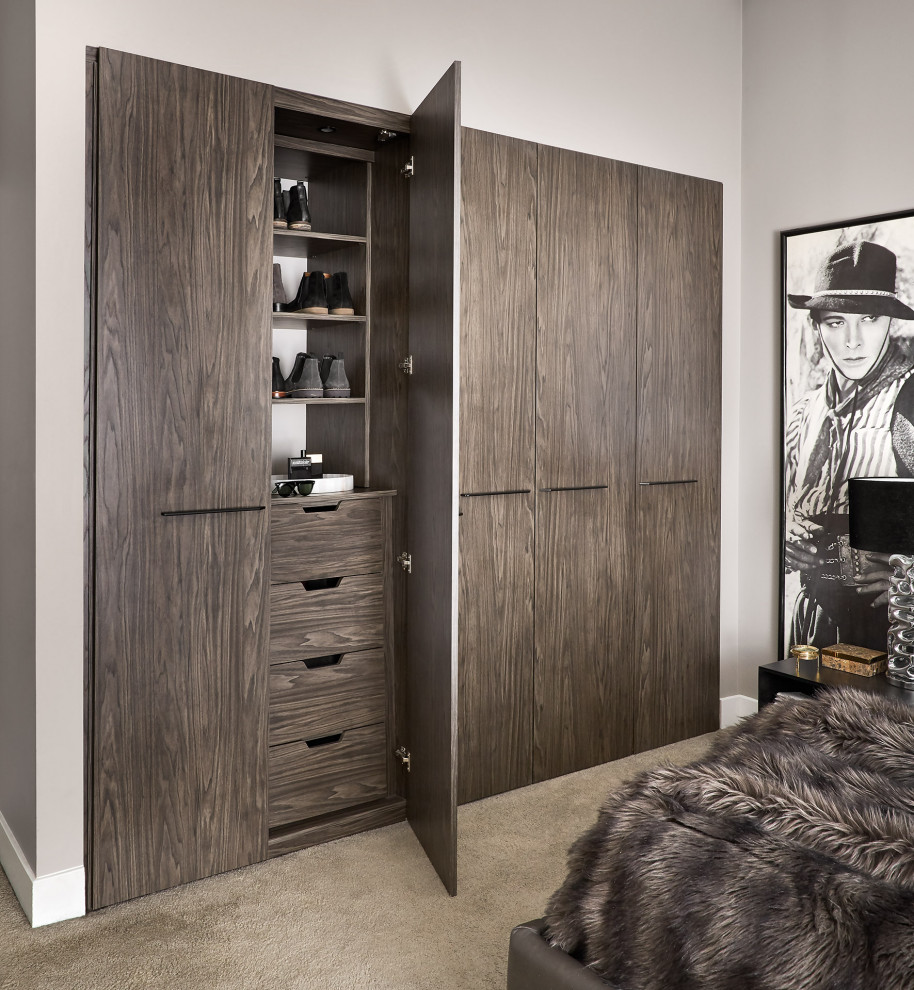 Inspiration for a large contemporary men's built-in wardrobe in Chicago with flat-panel cabinets, medium wood cabinets, carpet and beige floor.