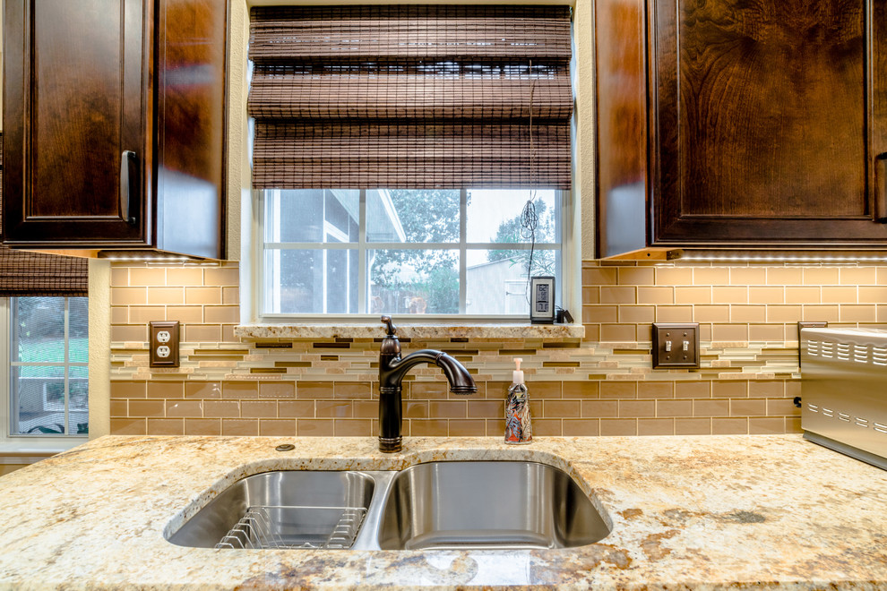 Inspiration for a small transitional galley porcelain tile enclosed kitchen remodel in Miami with an undermount sink, recessed-panel cabinets, brown cabinets, granite countertops, beige backsplash, glass sheet backsplash, stainless steel appliances and no island