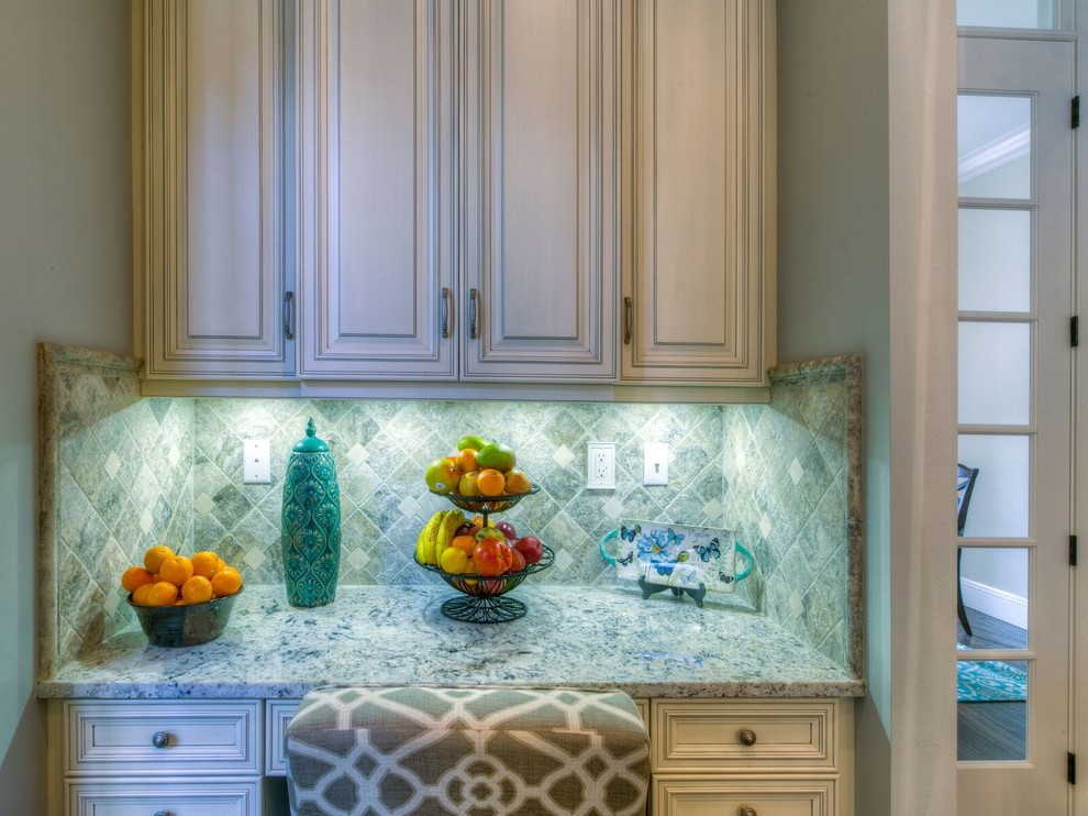Mid-sized transitional l-shaped light wood floor enclosed kitchen photo in Orlando with an undermount sink, recessed-panel cabinets, white cabinets, marble countertops, white backsplash, stainless steel appliances and an island