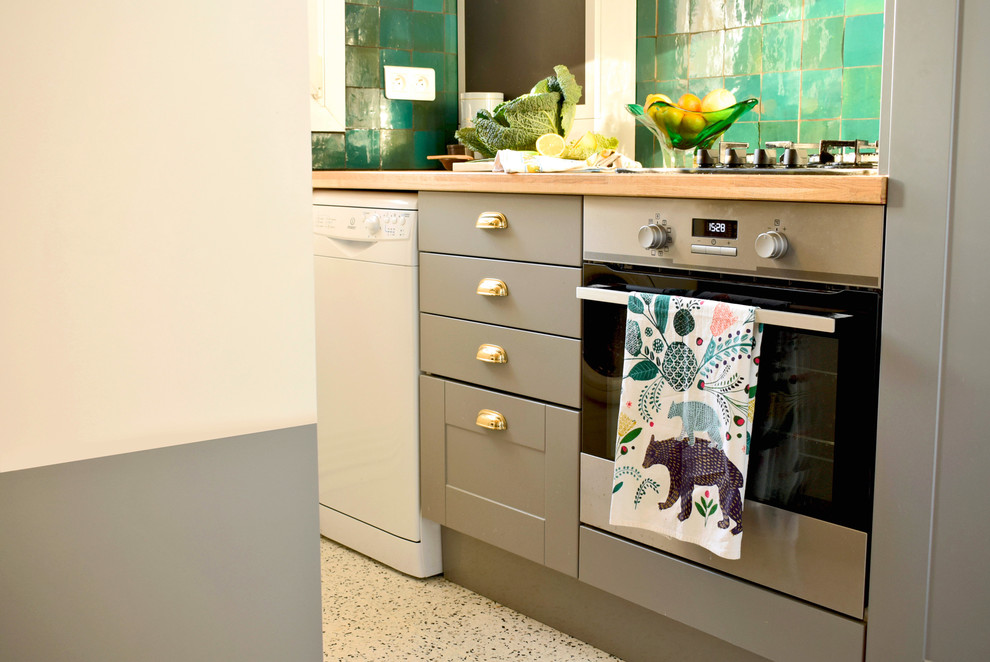 Inspiration for a small eclectic galley open plan kitchen in Paris with an undermount sink, grey cabinets, wood benchtops, green splashback, terra-cotta splashback, black appliances, terrazzo floors, with island and white floor.